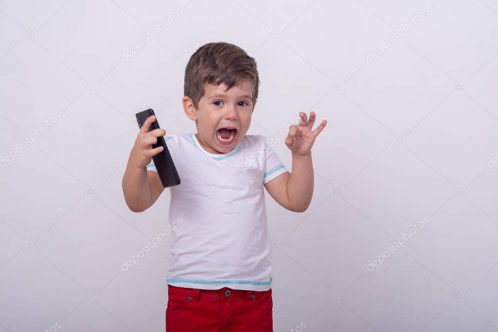 Scared kid with smartphone in his hands. Shocked child, shocking information on cell phone. Online risks and internet risks and internet child protection.