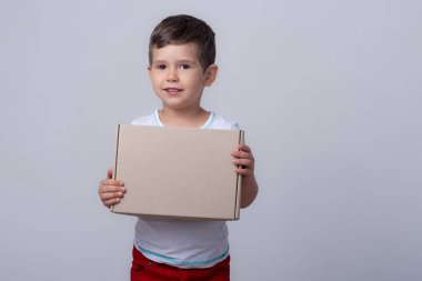 Dükkandan yeni satın almalar veya teslimatlar. Mutlu çocuk gülümseyerek kutuyu tutuyor. Çocuk Paket Teslim Ediyor.