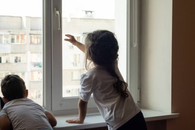 Çocuklar pencereyi açmaya çalışıyor. Evde Çocuk Güvenliği Penceresi Kısıtlayıcılar. 