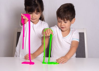 Child playing with slime. Kids squeeze and stretching slime. clipart