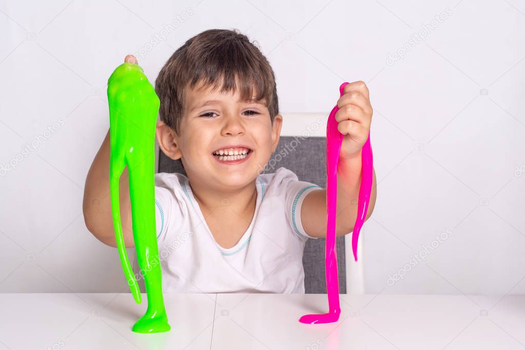 Boy play with slime. Kid squeeze and stretching toy slime.