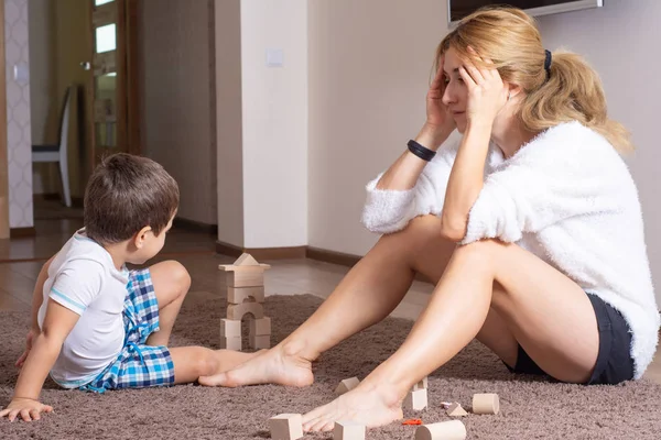 Tired and bored mother with 3 years old boy at home. 3 Year Old Childrens Behavior Crisis