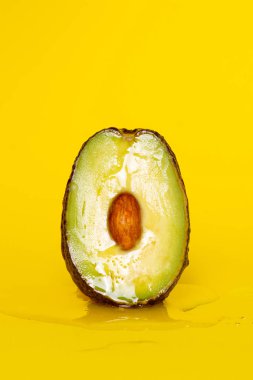 Sarı arka planda ballı avokado. Oral seks. Klitoral ya da vajinal orgazm. Ön sevişme konsepti. 