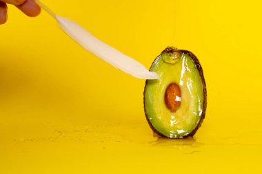 Avocado and feather on yellow background. Masturbation. Woman orgasm. Sex. Passion clipart