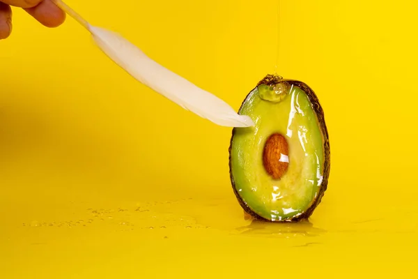 Avokado ve tüy sarı arka planda. Mastürbasyon. Kadın orgazmı. - Seks. Tutku
