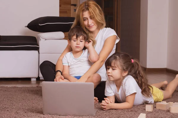 Молода Мама Діти Використовують Ноутбук Посміхаються Лежачи Разом Підлозі Вдома — стокове фото