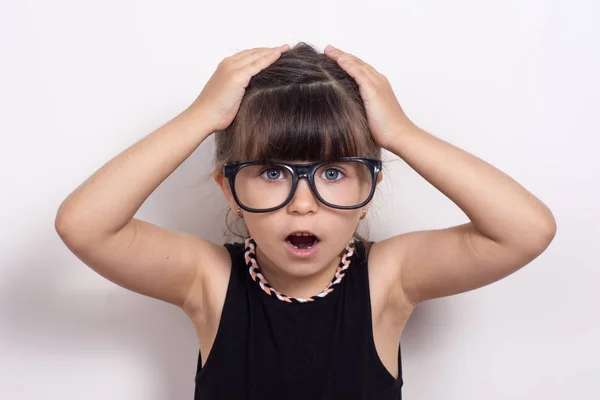 Headshot of surprised little preschooler girl with eyeglasses look at camera feel stunned amazed by unexpected. Happy small child isolated on white  background shocked by unbelievable surprise.