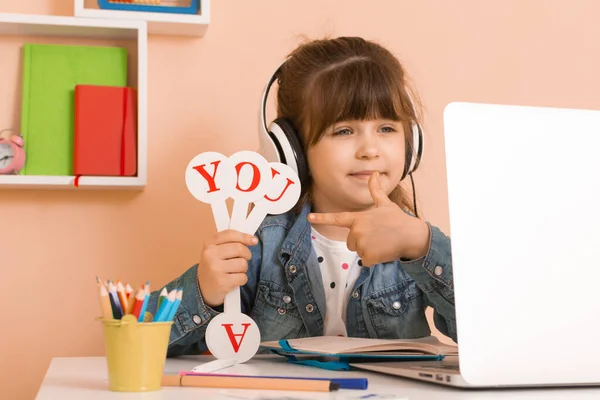 Çocuklarla İngilizce konsepti öğrenmek, dizüstü bilgisayarını kullanan bir kız. İngilizce öğrenmek için bilgisayarlı e-öğrenme videosu kullanan bir çocuk. 