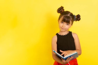 Sarı bir arkaplan portresi üzerinde elinde defter ya da kitapla gülümseyen liseli kız. Mutlu istihbarat çocuğu.. 