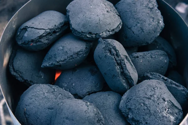 A pile of coal on a barbeque, getting ready for a summer grill.