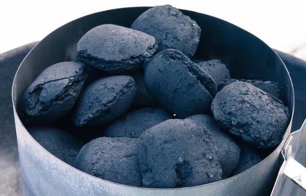 A pile of coal on a barbeque, getting ready for a summer grill.