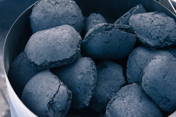 A pile of coal on a barbeque, getting ready for a summer grill.