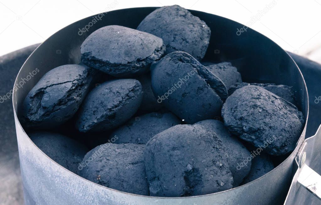 A pile of coal on a barbeque, getting ready for a summer grill.