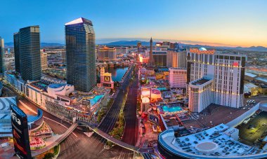 Nevada şehir merkezindeki Las Vegas Bulvarı 'nın altın saatinde modern otellerin, kumarhanelerin ve canlı şehirlerin görüntüsü Birleşik Devletler' in enerjisini yansıtan panoramik bir sahnede.