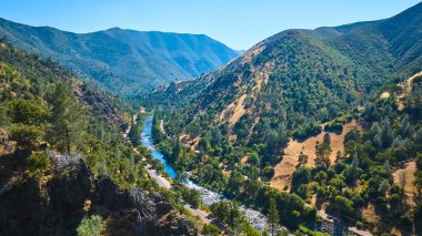 Merced Nehri 'nin Kaliforniya' da dağlarla çevrili yemyeşil bir vadiden akan havadan görünüşü Yosemite 'nin doğal güzelliğini ve manzarasını yakalıyor..
