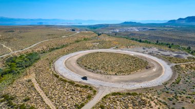 Lee Vining California yakınlarındaki dairesel bir inşaat alanının hava görüntüsü. Merkezi bir araç ve Mono Gölü 'ne uzanan engin bir çöl manzarası..