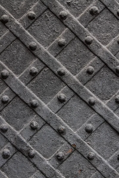 Detail of wrought iron door with a metal plate twisted and sculpted nails