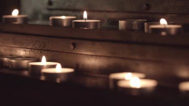 masanın üstündeki mumlardan mumlar için, mumlar için kilise masasının altındaki mumlar için odak değiştirme.renk düzeltme olmadan, yakın çekim.