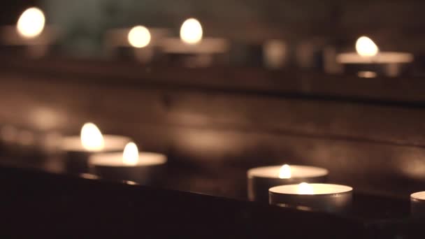 将焦点从前景中的蜡烛 位于桌子底部 更改为教堂桌子顶部背景中的蜡烛 无颜色校正 — 图库视频影像