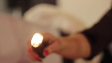 elinde kız tutar ve başka bir kızın arkasına damlayan balmumu, iki mum kaydırır