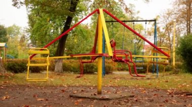 Boş bir çocuk atlıkarıncasının hareketi. Atlıkarınca saat yönünün tersine ortalama hızda hareket eder. Sonbahar. Tam HD, ses yok.