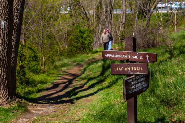 Keedysville, MD, USA - April 10, 2016: Hikers approach a sign along the Appalachian Trail in Washington County, MD.
