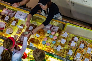 Lancaster, Pa, Amerika Birleşik Devletleri - 11 Nisan 2015: Bir müşteri bir standholder Lancaster Merkez Market bir fırın ürün satın.