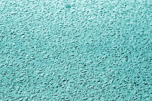 Dirty asphalt road texture with blur effect in cyan tone. Abstract background and texture for design.