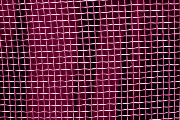 Metal mesh grid pattern in pink tone. Abstract background and texture.