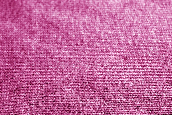 Knitting pattern with blur effect in pink color. Abstract background and texture for design.