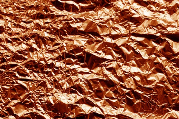 Metal foil texture in orange color. Abstract background and texture for design.