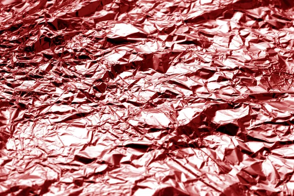 Metal foil texture in red tone. Abstract background and texture for design.