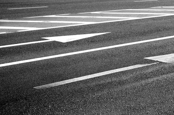 Urban asphalt road with arrows and marks on it. Traffic signs and symbols.