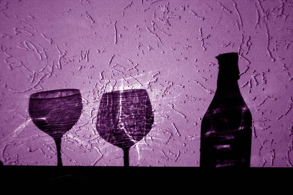 wine bottle and two glasses shadow in purple. Abstract backround and view