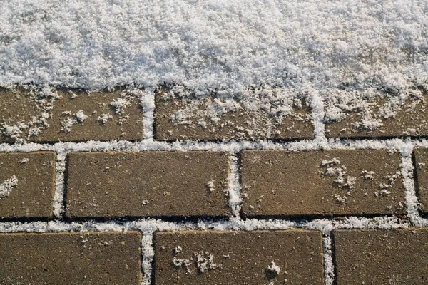 Snow on urban pavement. Seasonal background texture for design.