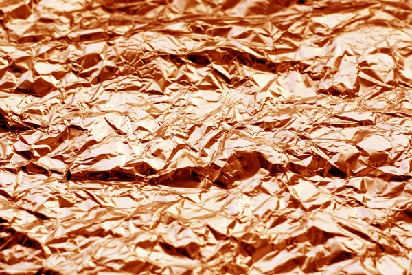Metal foil texture in orange tone.