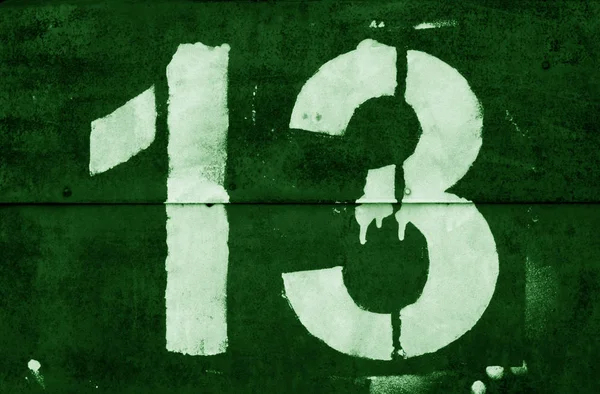 Numero 13 in stencil su parete metallica in tono verde . — Foto Stock