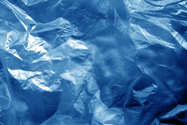 Superficie plástica transparente arrugada en tono azul marino . — Foto de Stock