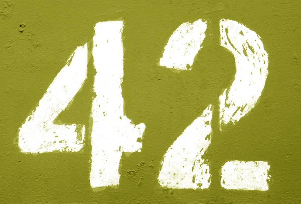 Numero 42 in stencil su parete metallica arrugginita in tono giallo . — Foto Stock