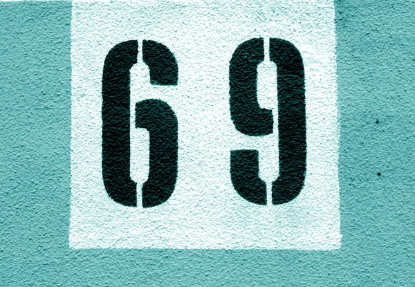 Numer 69 na ścianie cementowej we wzorniku w odcieniach błękitu. — Zdjęcie stockowe