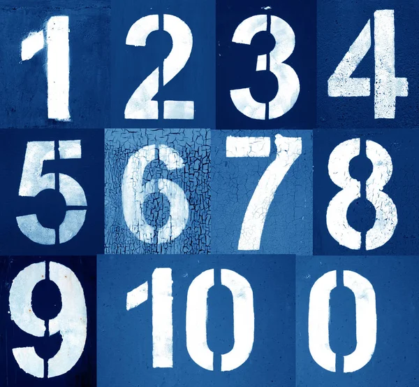 Numbers 0 to 10 in stencil on metal wall in navy blue tone.