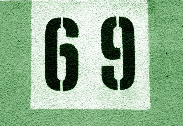 Número 69 en la pared de cemento en plantilla en tono verde . — Foto de Stock