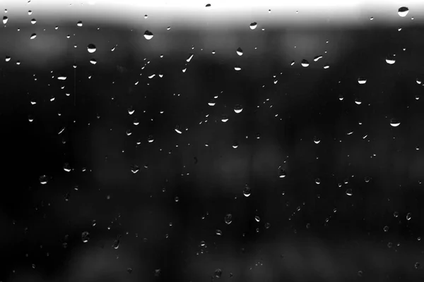 Rain drops on window with blured background in black and white. — Stock Photo, Image