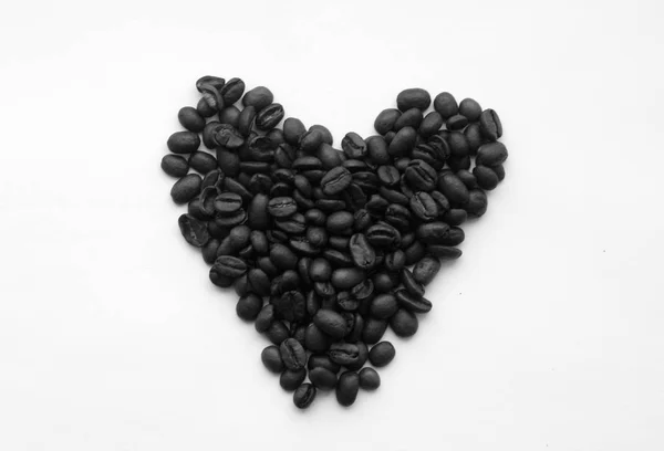 Grains de café en forme de coeur sur blanc en noir et blanc . — Photo