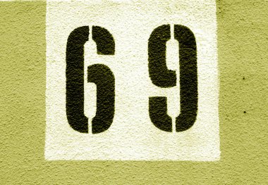 Sarı tonda şablon çimento duvarda 69 numara.