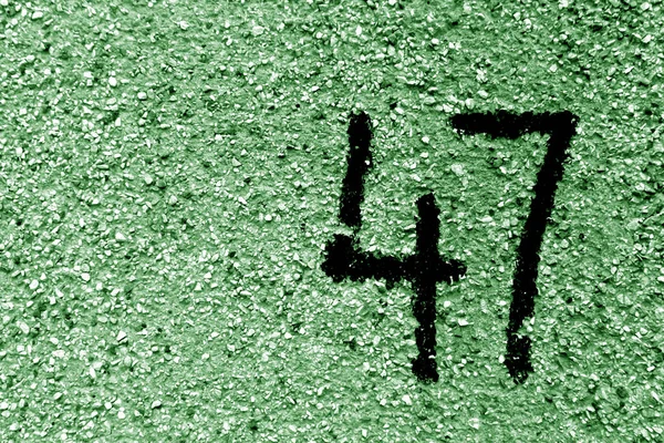 Numéro 47 sur mur de ciment au pochoir dans le ton vert . — Photo