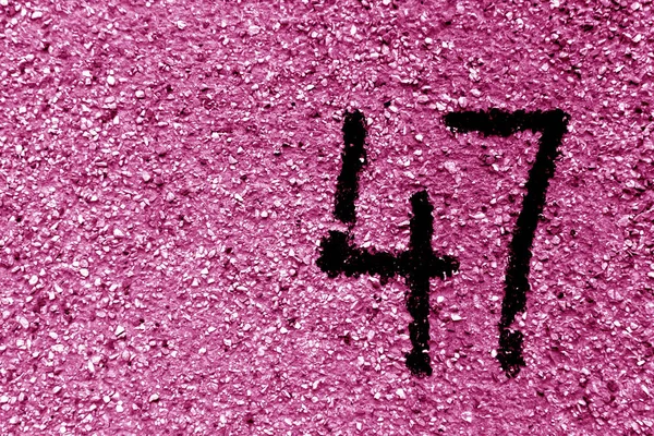 Nummer 47 på cement vägg i stencil i rosa ton. — Stockfoto