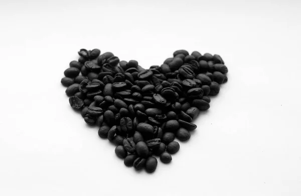 Grãos de café em forma de coração em branco em preto e branco . — Fotografia de Stock