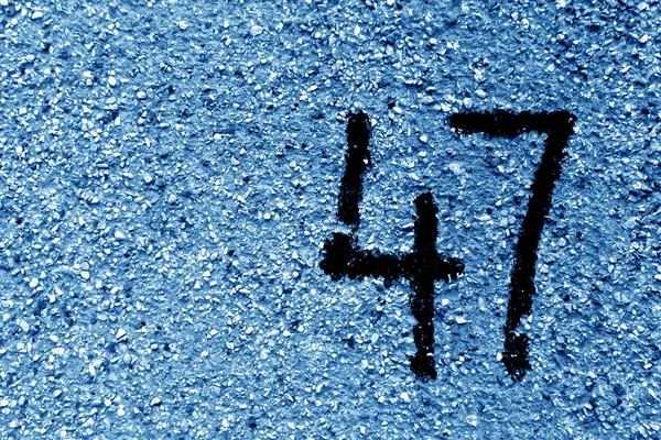 Nummer 47 på cement vägg i stencil i marinblå ton. — Stockfoto
