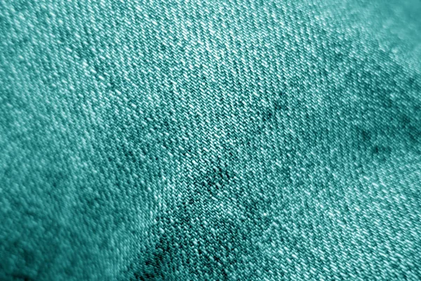 Jeans cloth pattern in cyan color with blur effect.